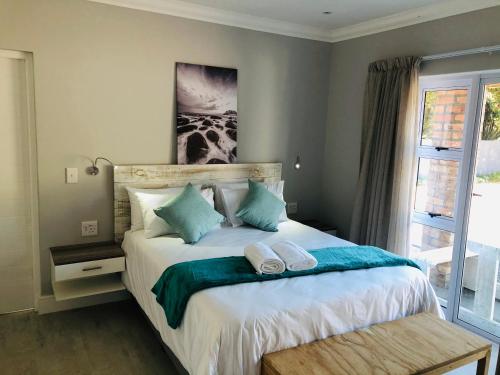um quarto com uma cama com duas almofadas em Hermanus Guest Rooms em Hermanus