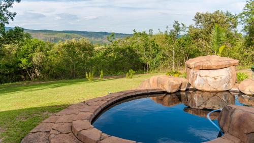 a pool of water with a rock bridge at Cuckoo Ridge Country Retreat in Hazyview