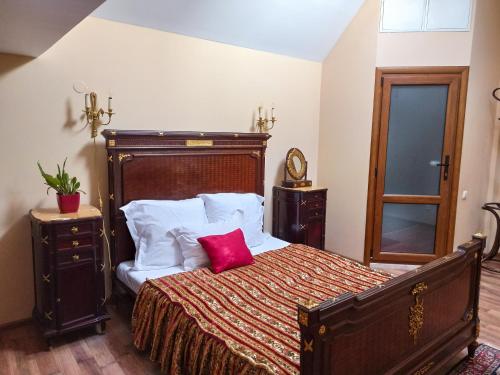 a bedroom with a large bed with red pillows at Вілла Графа in Lviv