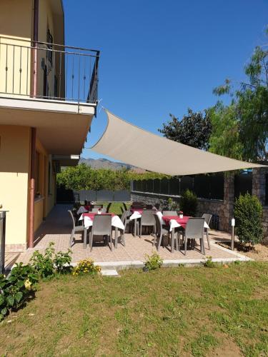 a patio with tables and chairs and a white canopy at B&B Villa Chiara - Bed And Breakfast in Taormina