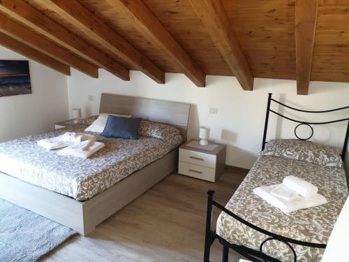 a bedroom with two beds and a wooden ceiling at B&B Villa Chiara - Bed And Breakfast in Taormina