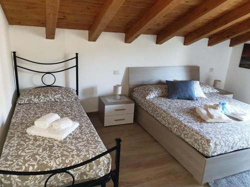 a bedroom with two beds and a wooden ceiling at B&B Villa Chiara - Bed And Breakfast in Taormina