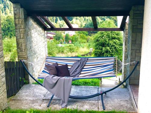 a hammock with pillows sitting on a porch at Sielanka w Brennej in Brenna