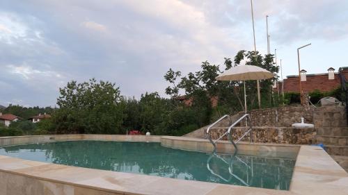 uma piscina com um guarda-sol ao lado de uma piscina em Family Hotel Belvedere em Dŭlgopol