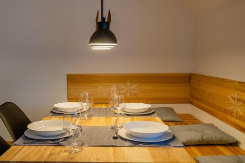 uma mesa de jantar com pratos e copos de vinho em Rent like home - Za Cieszynianką 3 em Zakopane
