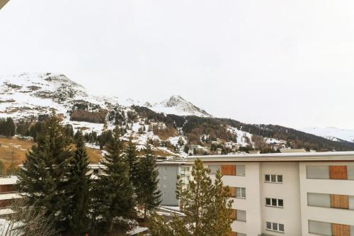 a building with a snow covered mountain in the background at Casa Bünda in Davos
