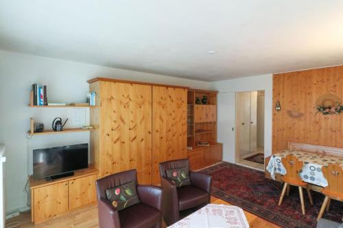 a living room with wooden walls and a table and chairs at Casa Bünda in Davos