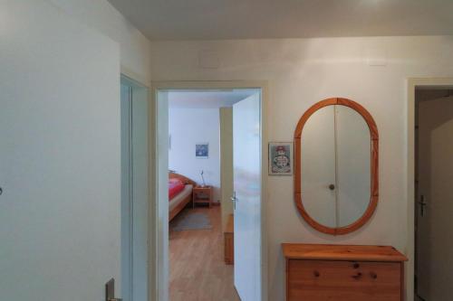 a room with a mirror and a wooden dresser at Casa Bünda in Davos