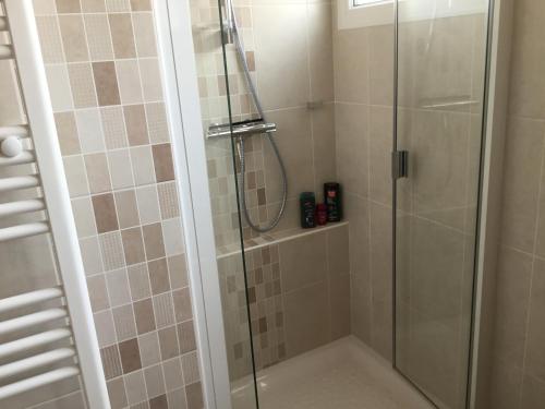 une salle de bain avec une douche avec une porte vitrée dans l'établissement Maison de vacances à St JEAN DE MONTS, à Saint-Jean-de-Monts