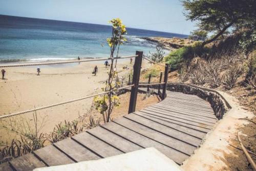 a stairway leading to a beach with people on it at Plateau Bedroom & Chambre - Praia Center 1 in Praia