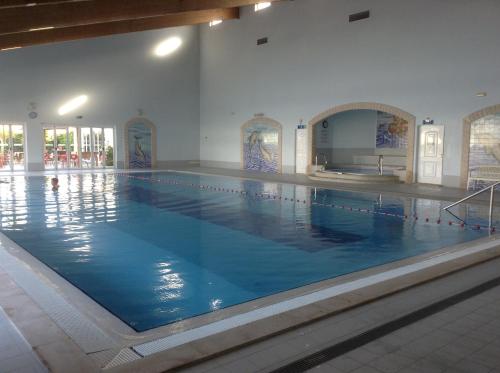a large swimming pool with blue water in a building at Votre appartement a Portimao in Portimão