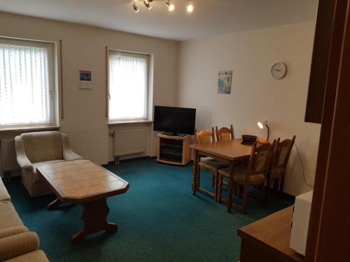 a living room with a table and a television at Ferienwohnung Viktoria in Bad Bertrich