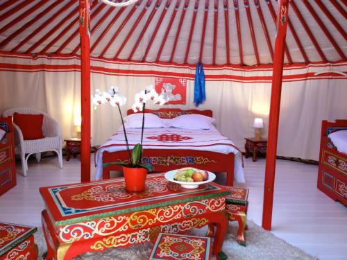 a bedroom with a bed and a table with a bowl of fruit at Home Paradis & Spa - Ecolodge in Souvigné
