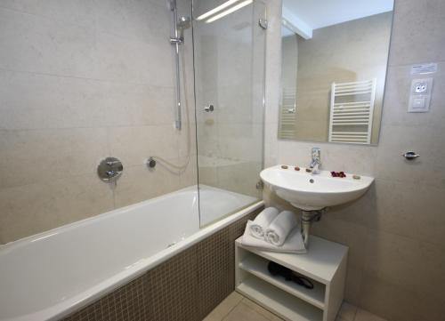 bagno con lavandino, doccia e vasca di River View Residence a Praga