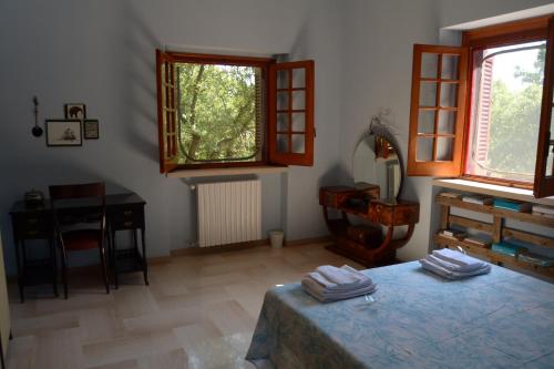 Cette chambre comprend un lit, un bureau et des fenêtres. dans l'établissement Par Tòt, à Locorotondo