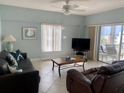a living room with two couches and a tv at Island House Beach Resort 16N in Siesta Key