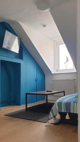 une chambre avec une table et un mur bleu dans l'établissement Bel appartement F2 centre ville, au Havre
