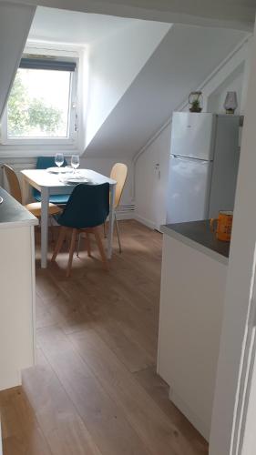 une cuisine et une salle à manger avec une table et un réfrigérateur dans l'établissement Bel appartement F2 centre ville, au Havre