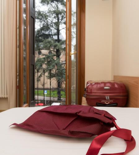a red ribbon sitting on top of a bed at Hotel Casa Del Pellegrino in Padova