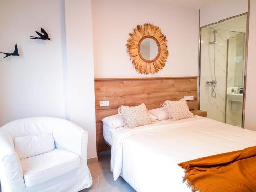 sypialnia z białym łóżkiem i krzesłem w obiekcie Bonefish Apartment w mieście Villajoyosa