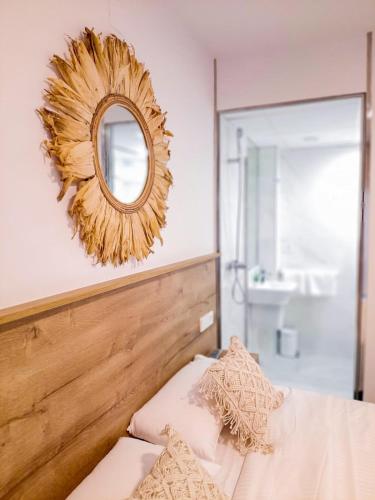 a mirror on a wall above a bed in a bedroom at Bonefish Apartment in Villajoyosa
