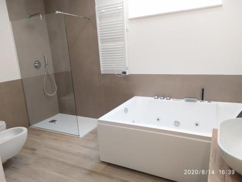 a bathroom with a tub and a sink and a shower at Manolo Case Vacanza in Monopoli
