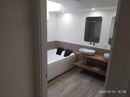 a bathroom with two sinks and a bath tub at Manolo Case Vacanza in Monopoli