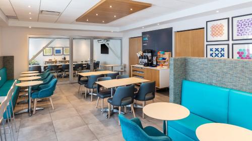 a restaurant with tables and chairs and a counter at Holiday Inn Express Quebec City-Sainte Foy by IHG in Quebec City