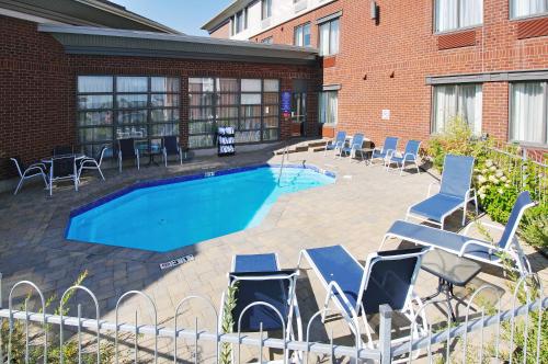 a swimming pool with lounge chairs and a building at Holiday Inn Express Quebec City-Sainte Foy by IHG in Quebec City