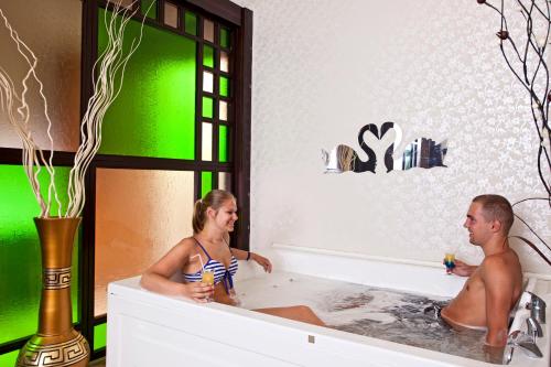 un homme et une femme assis dans une baignoire dans l'établissement Titan Select Hotel Ultra All Inclusive, à Konaklı