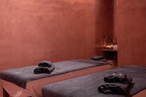 two beds in a room with towels on them at Koukoumi Vegan Boutique Hotel in Ano Mera