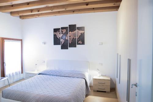 een witte slaapkamer met een bed en een houten plafond bij Vicolo J. Da Ponte - Bassano Centro Storico in Bassano del Grappa