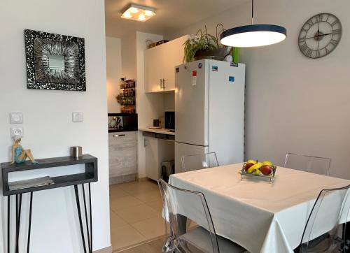 une cuisine avec une table et un réfrigérateur blanc dans l'établissement Appartement cosy centre de Wimereux proche plage, à Wimereux