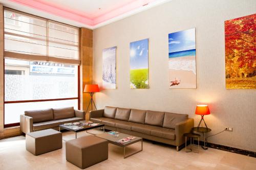 a living room with a couch and a table at Hôtel Les Saisons in Casablanca