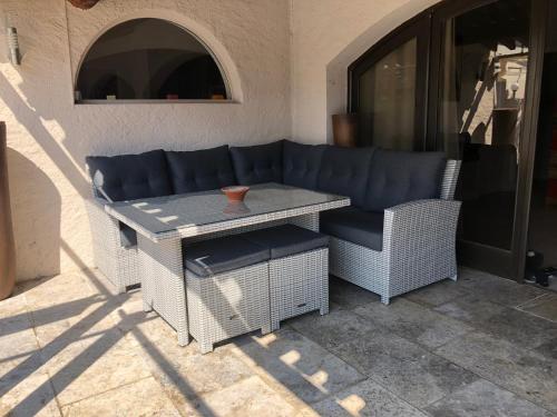 a couch and a table on a patio at Logis Hôtel Restaurant Les Aubuns in Caissargues