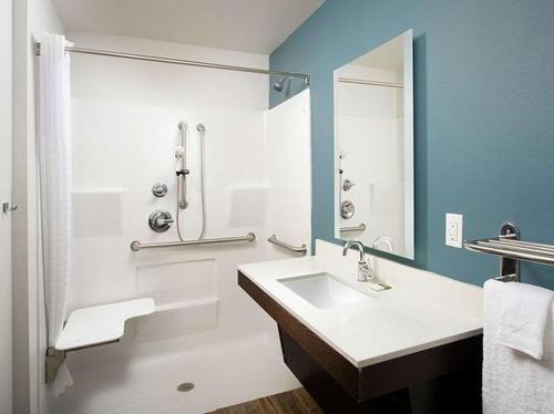 a bathroom with a sink and a shower at WoodSpring Suites Plano - North Dallas in Plano