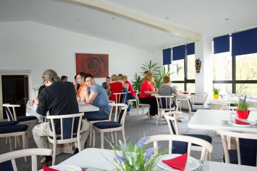a group of people sitting at tables in a restaurant at Hotel Sonnenkeller in Neu Ulm