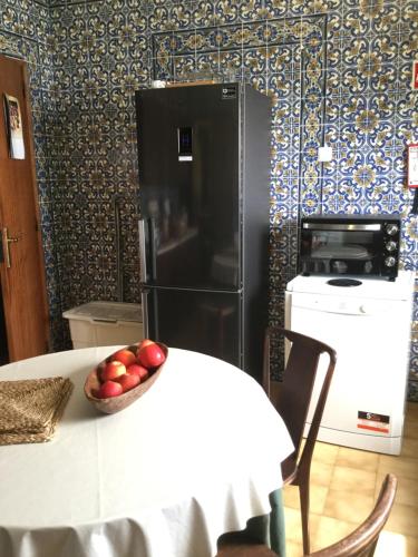 a kitchen with a table with a black refrigerator at AmendoeirasHouse-SustainableLiving in Abrantes