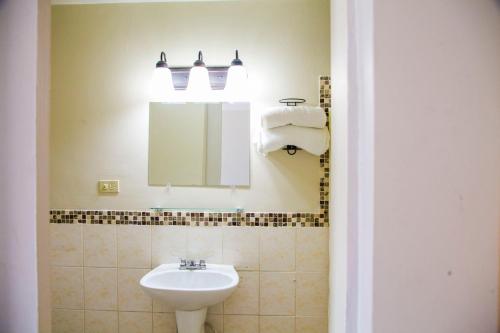 a bathroom with a sink and a mirror at Hotel Cosmos Don Carlos in Mexicali