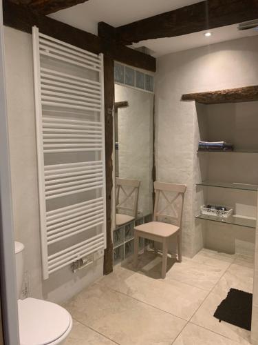 a bathroom with two chairs and a toilet at La Maison De Chloe in Senouillac