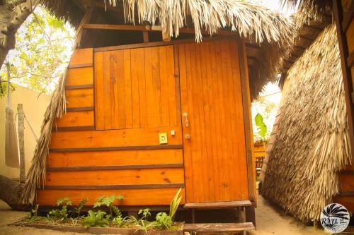 a wooden door of a hut with a thatch roof at Raiz Kite Cabana in Jericoacoara