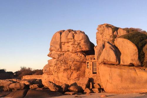 a building sitting on top of a large rock at Maison avec SPA côte de granit rose in Trégastel