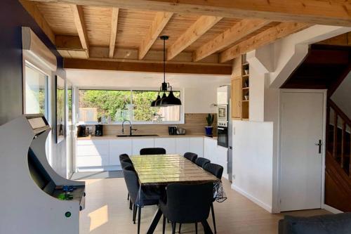 a kitchen with a table and chairs in a kitchen at Maison avec SPA côte de granit rose in Trégastel