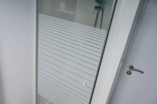 a glass shower door with a mirror on it at Maison avec SPA côte de granit rose in Trégastel