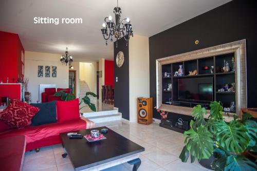 a living room with a red couch and a table at Helmata Villa with privecy in Argostoli