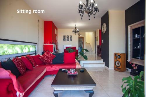 a living room with a red couch and a table at Helmata Villa with privecy in Argostoli