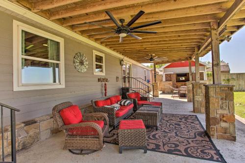 a covered porch with chairs and a ceiling fan at Lakefront Retreat with Pier, Bar Hut and Fireplace! in Graford