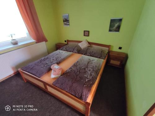 a bedroom with a bed with purple sheets and a window at Motel Podkova in Klobouky u Brna