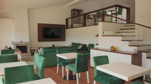 a restaurant with green chairs and tables and a staircase at Quinta da Portela Douro in Armamar