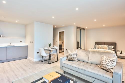 a living room with a couch and a kitchen at Seven Living Bracknell - Serviced Apartments in City Centre - Free Parking in Bracknell